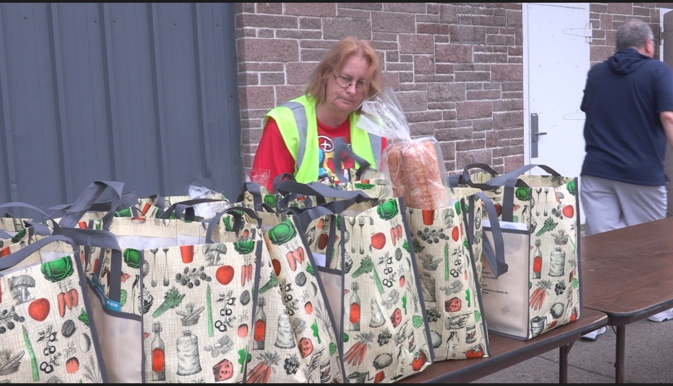 Woman/volunteer in front of table of bags